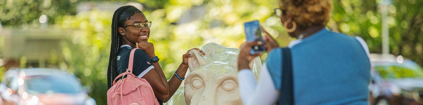 A female student poses for a photo at the Lion Shrine